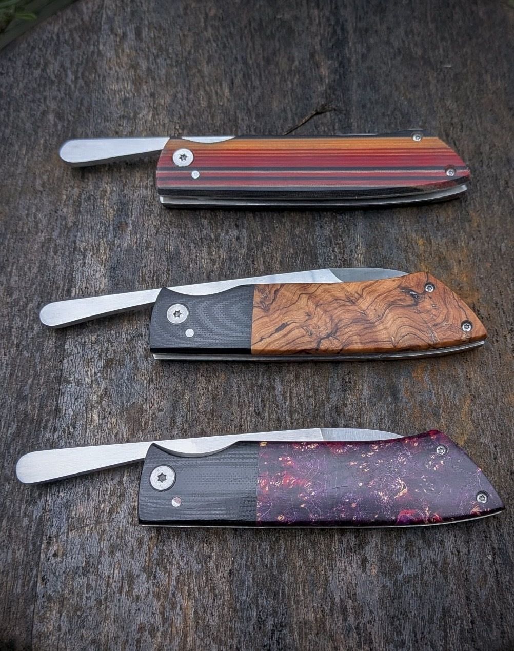 Three handmade folding knives closed, showing handle detail